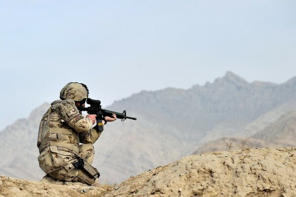 Photo d un soldat avec des armes dans les montagnes