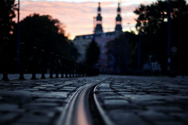 Calle nocturna en tonos grises bajo el cielo rosado de la puesta de sol