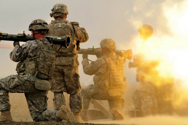 Soldiers shoot from a large weapon