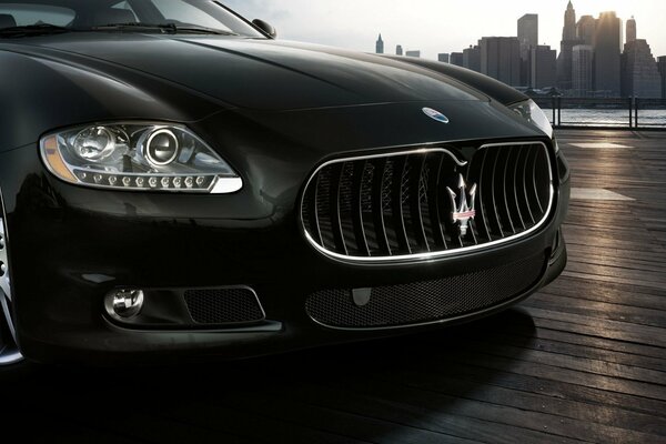 Black maserati on the background of skyscrapers