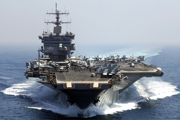 Photo of an aircraft carrier at sea with planes