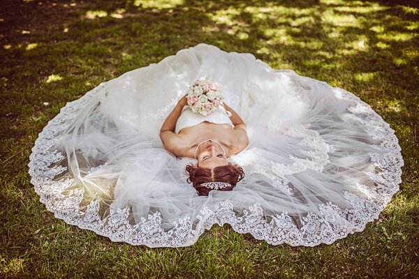 Die Braut im Kleid hält einen Blumenstrauß