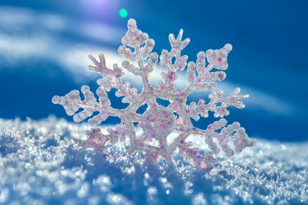 Copo de nieve brillante sobre nieve blanca