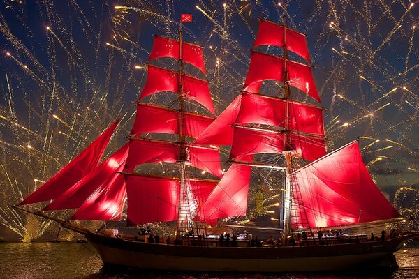 Barco velero en el desfile. Fuegos artificiales en el cielo nocturno