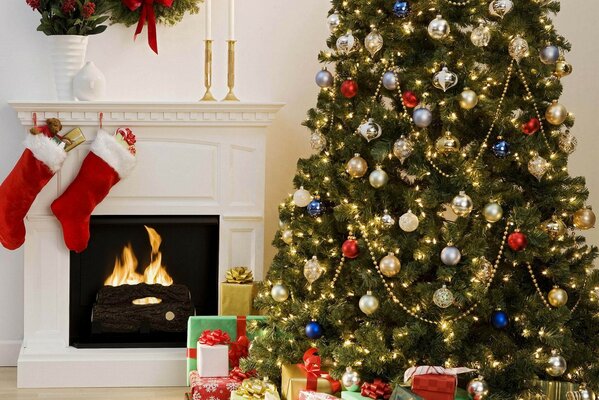 An elegant Christmas tree with gifts under it and a fireplace with socks