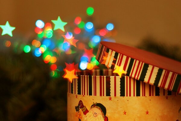 A Christmas box from which glowing lights fly