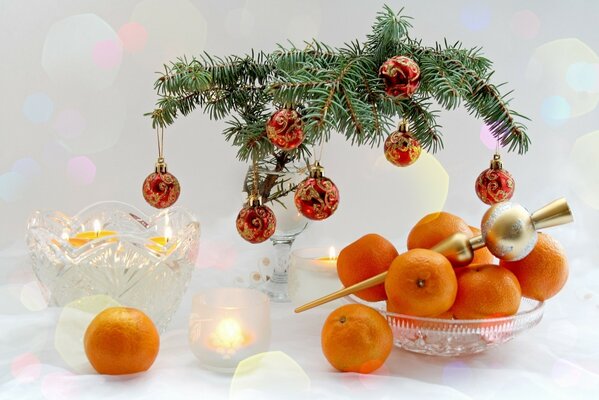 Mesa de año nuevo con rama de árbol de Navidad y mandarinas en jarrones 