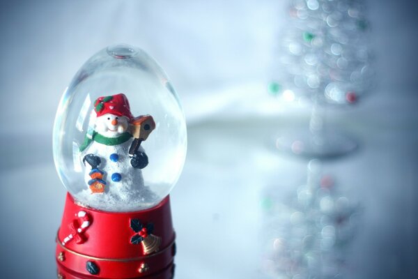 Bonhomme de neige en boule de Noël sur fond gris