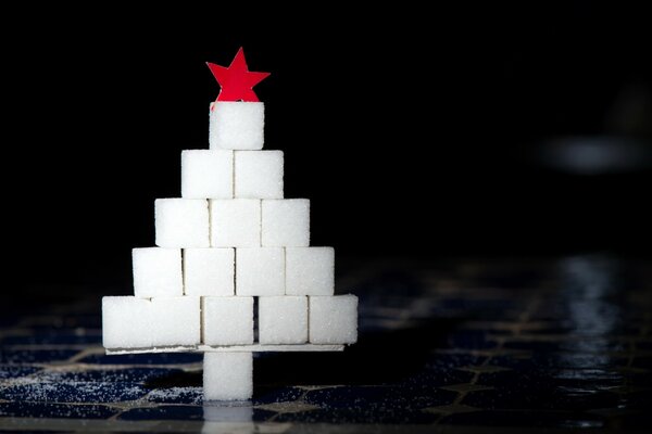 Árbol de Navidad con una estrella roja sobre un fondo negro