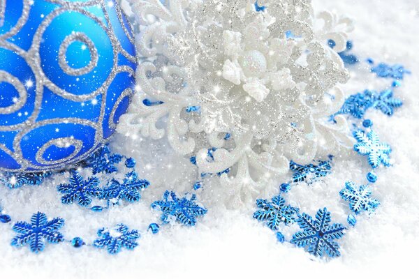 Boule de fête sur la neige avec des flocons de neige bleus