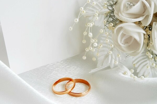 White flowers and wedding rings