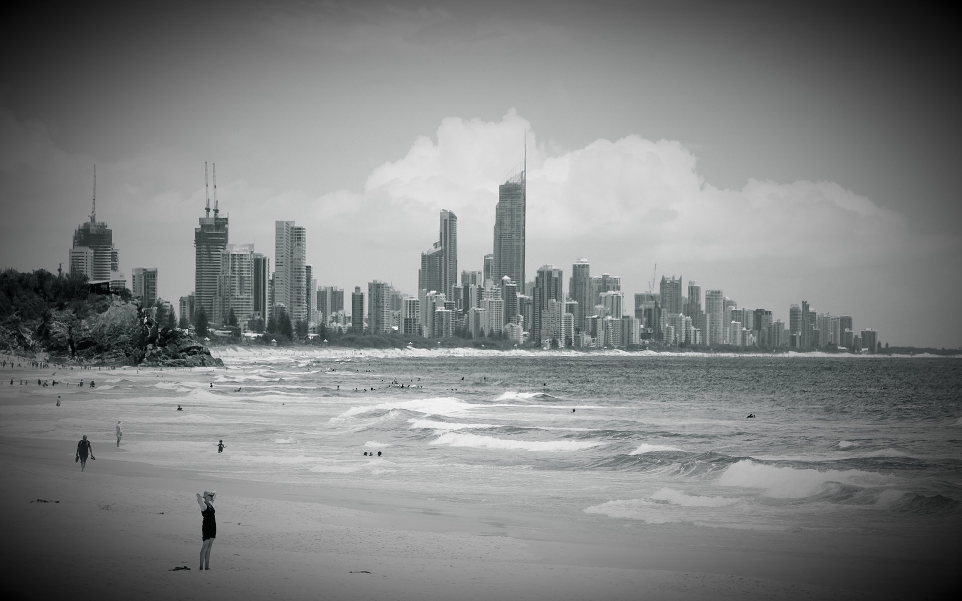 ciudad playa edificios rascacielos cielo nubes agua océano olas gente bañarse paraíso para surfistas