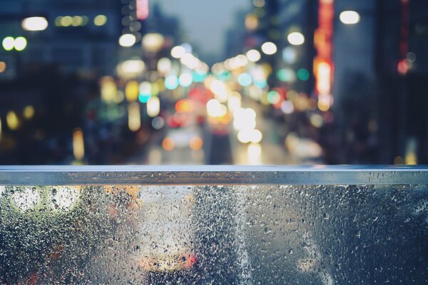 Drops on the glass, against the background of the city