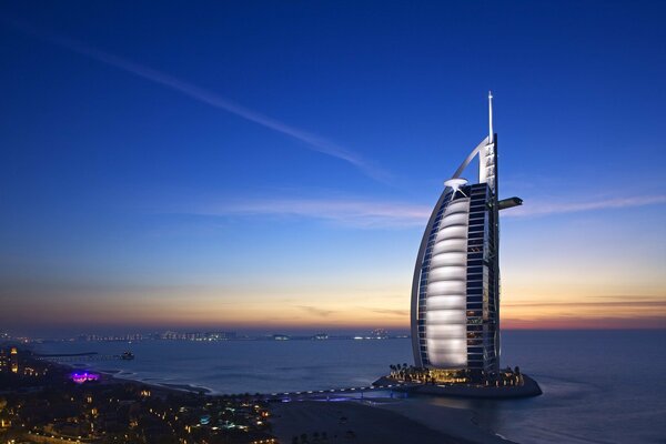 The luxurious Burj al-Arab skyscraper towering over the sea at night