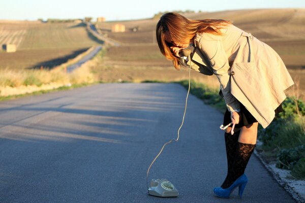 Fille avec téléphone fixe sur la route