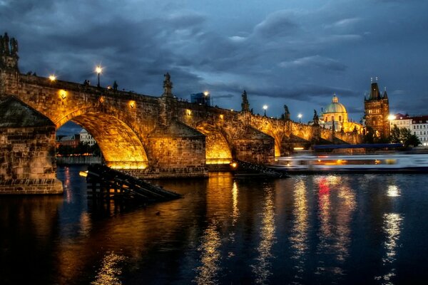 Praga notturna con le luci del ponte