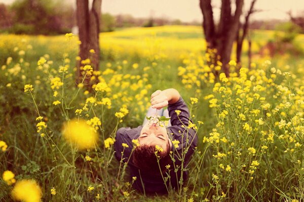 Ein Mann auf einem Feld unter den gelben Blumen