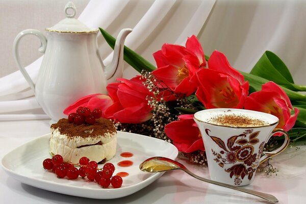 Eine Tasse Kaffee mit einem schönen Dessert, garniert mit Beeren