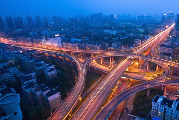 Illuminated city flyover at dusk from a bird s-eye view