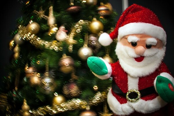 Giocattolo przdnichny di Babbo Natale sullo sfondo di un albero di Natale dipinto