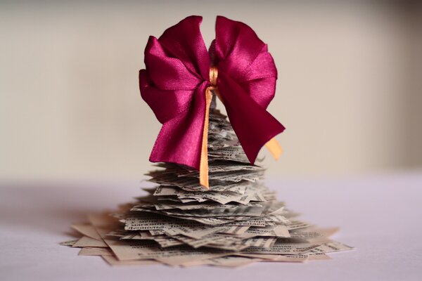 Christmas tree made of newspapers with a satin bow