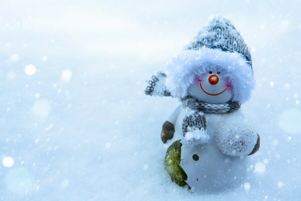 Lindo muñeco de nieve sonríe en la nieve