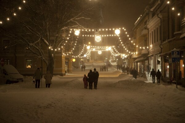 Calle de invierno iluminada con guirnaldas de Navidad