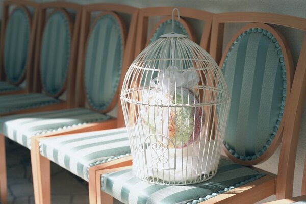 Wedding bouquet in a cage on a striped chair