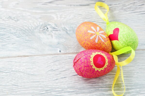 Three colorful Easter eggs with yellow ribbons