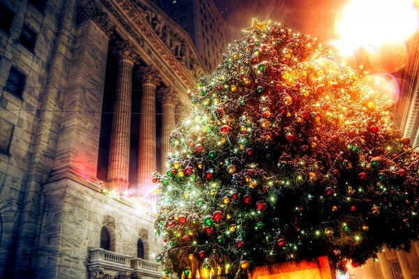 A bright fir tree decorated with Christmas toys in the building