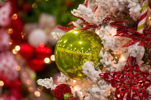 The green ball is hanging on the Christmas tree