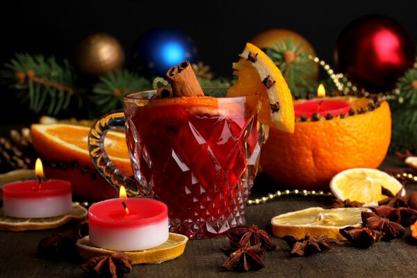 Mug with mulled wine among candles