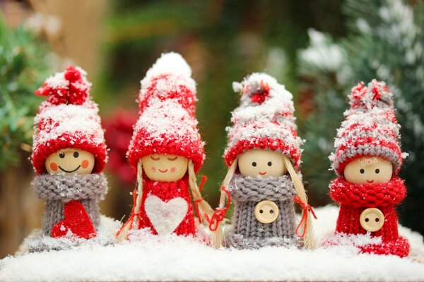 Toys in knitted clothes are sprinkled with snow