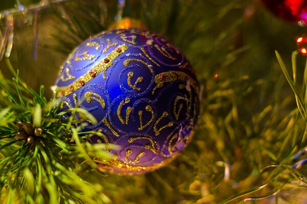 Un giocattolo di Natale blu con un motivo dorato pesa sull albero di Natale