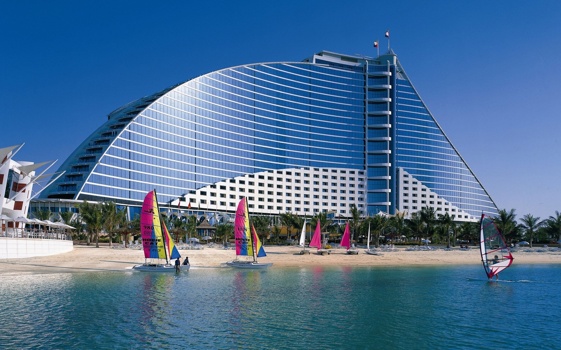 edificio ventanas forma diseño costa playa catamaranes surfistas velas resort turismo