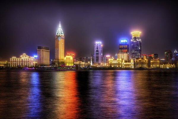 Paesaggio notturno con luci nelle finestre e il loro riflesso nell acqua