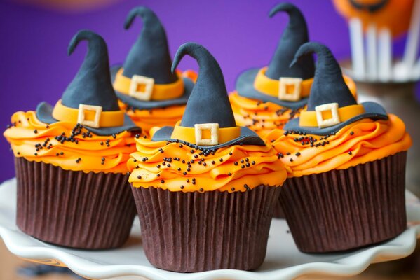 Cupcakes with cream decorated with hats for halloween