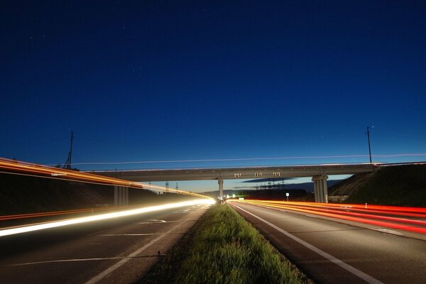 Der Abendhimmel über der von Lichtern beleuchteten Autobahn