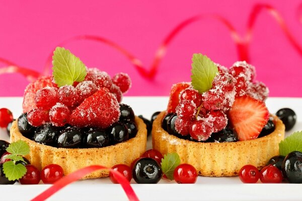 Shortbread tartlets with mint leaves and strawberries and currants