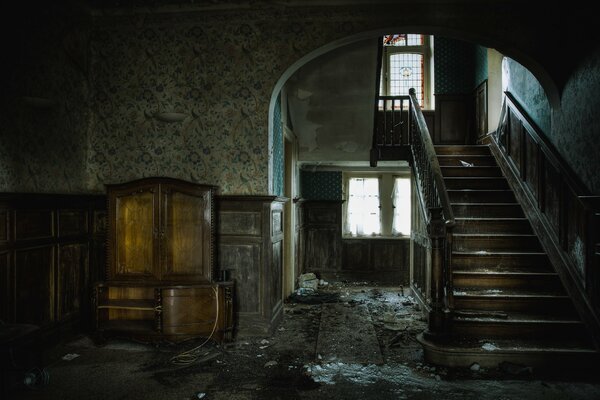 An abandoned room with a staircase in the house