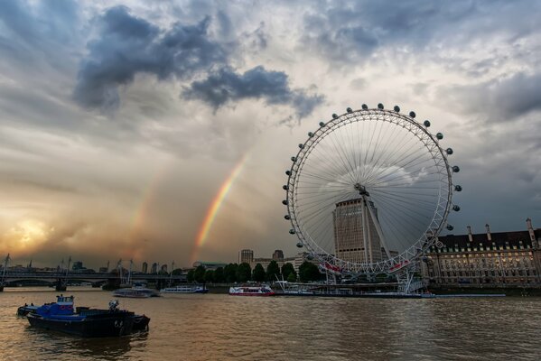 London Ferris wheel by the water and rainbow