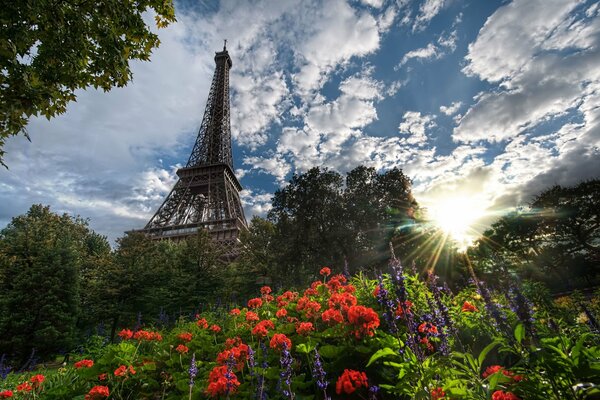 Eiffel Tower in red colors against the sky with clouds