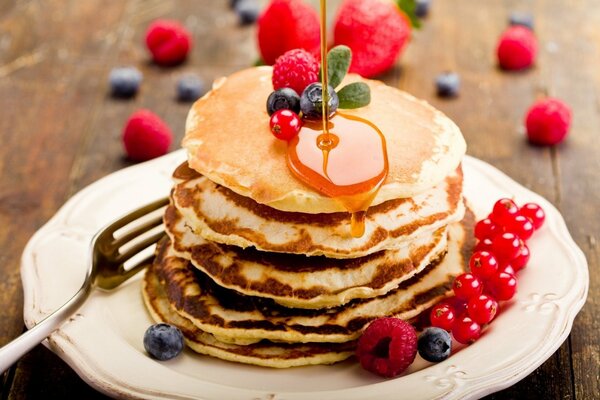 Ein Stapel Pfannkuchen mit Honig und Beeren