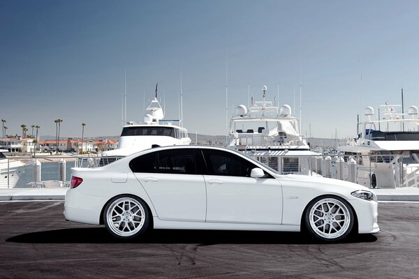 White BMW on the background of white yachts