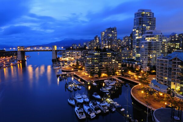 The illuminated embankment with ships and yachts