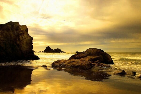 Sunset and rocks are displayed in the water