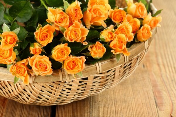 Bouquet of roses in a basket on a wooden table