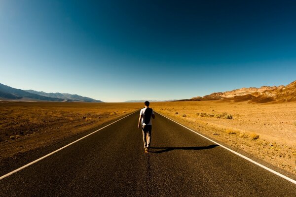 A man is walking somewhere along the highway