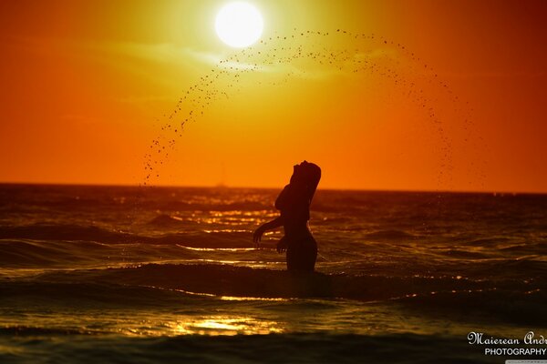 Mädchen im Wasser auf Sonnenuntergang Hintergrund