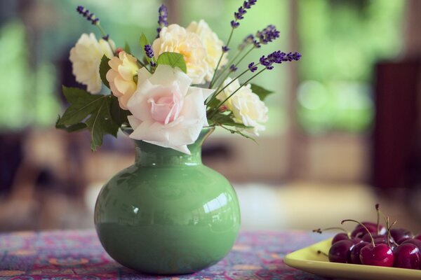 A small vase and cherries on the table